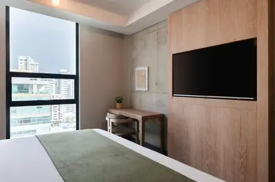 a bedroom with a bed and a flat screen tv at OZ Hotel Collection in Cartagena de Indias