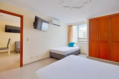 a bedroom with two beds and a tv on the wall at Espectacular vista piso 20 in Cartagena de Indias