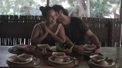 a man and woman sitting at a table with food at Casa Surya - Cabaña sostenible en la naturaleza in San Onofre