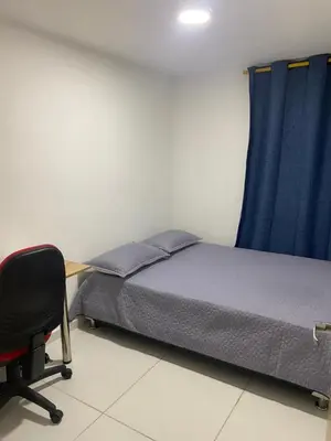 a bedroom with a bed and a desk and a chair at Apartamento alameda del Rio in Barranquilla