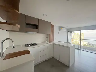 a kitchen with white cabinets and a large window at Oasis Vista al Mar in Cartagena de Indias