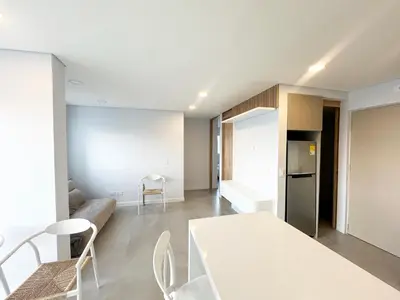 a kitchen and living room with a white table and chairs at Oasis Vista al Mar in Cartagena de Indias