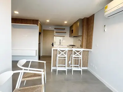 a small kitchen with white chairs and a counter at Oasis Vista al Mar in Cartagena de Indias