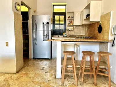 a kitchen with a refrigerator and two bar stools at by Calamari Homes - El Porvenir 306 walled city in Cartagena de Indias