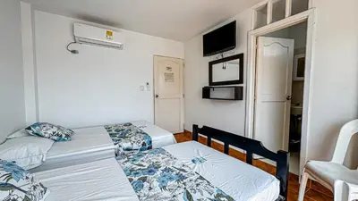 a small room with two beds and a tv at Hotel Santiago de Tolú in Santiago