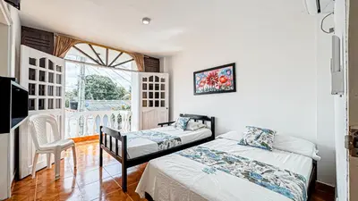 a bedroom with two beds and a balcony at Hotel Santiago de Tolú in Santiago
