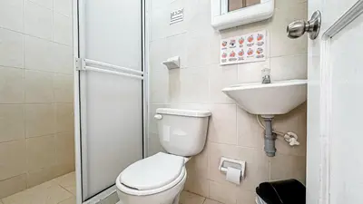 a bathroom with a toilet and a sink and a shower at Hotel Santiago de Tolú in Santiago