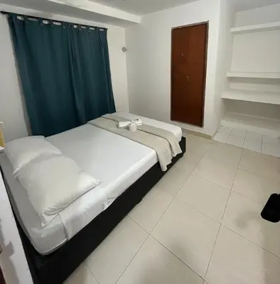 a bedroom with a large bed with a blue curtain at Stay Mar y Playa House in Cartagena de Indias