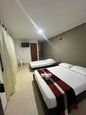 a hotel room with two beds and a television at Stay Mar y Playa House in Cartagena de Indias