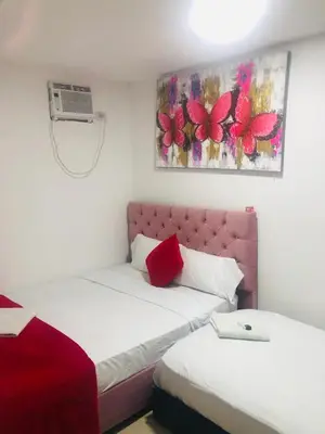 a bedroom with two beds and a pink headboard at Hotel Altos del Prado in Barranquilla