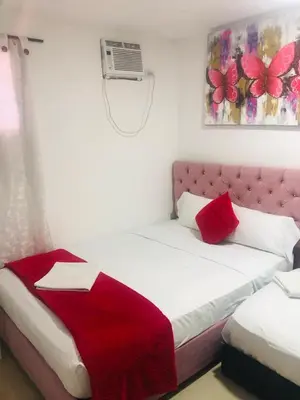 a bedroom with a bed with a red blanket on it at Hotel Altos del Prado in Barranquilla