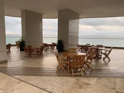 a patio with tables and chairs and the ocean at Confort Total con Vista al Mar 11 in Cartagena de Indias