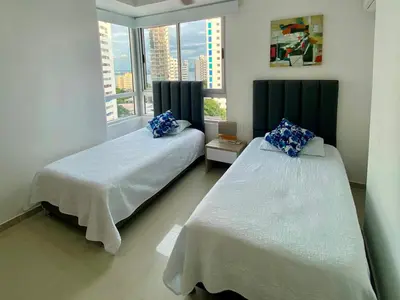 two beds in a room with a window at Confort Total con Vista al Mar 11 in Cartagena de Indias