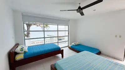 a bedroom with two beds and a large window at Cabaña Costa de Oro in San Antero
