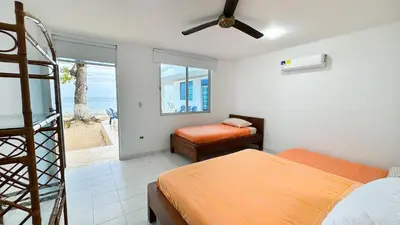 a bedroom with two beds and a view of the ocean at Cabaña Costa de Oro in San Antero