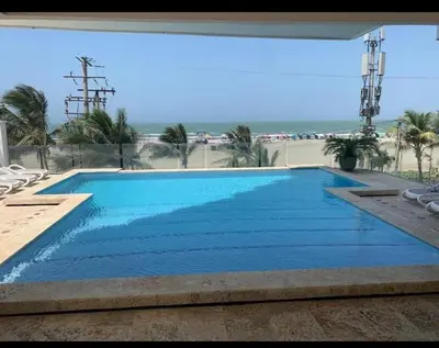 a large blue swimming pool with a view of the ocean at Aire puro frente al mar edificio sunshine in Cartagena de Indias