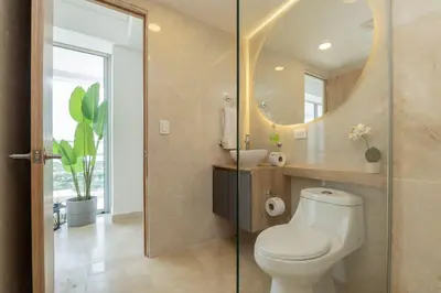 a bathroom with a toilet and a sink and a mirror at CB1629 | Suite moderna con vista 180 mar ciudad in Cartagena de Indias