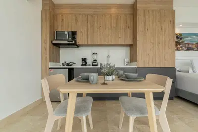 a dining room table with chairs and a kitchen at CB1629 | Suite moderna con vista 180 mar ciudad in Cartagena de Indias