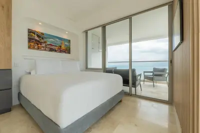 a bedroom with a large white bed and a balcony at CB1629 | Suite moderna con vista 180 mar ciudad in Cartagena de Indias
