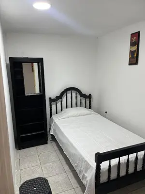 a bedroom with a black bed and a mirror at Habitacion privada con servicios incluidos in Barranquilla