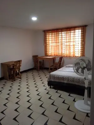 a bedroom with a bed and a table with a fan at Habitacion privada con servicios incluidos in Barranquilla
