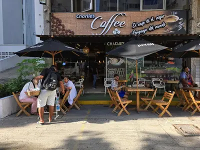 a group of people standing outside of a cafe with umbrellas at Moderna suite con balcón a pasos de la playa in Cartagena de Indias