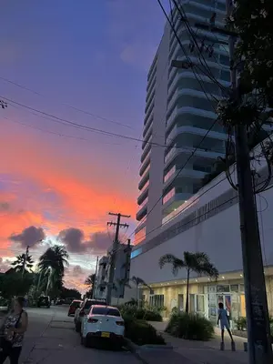 a person walking down a street in front of a tall building at Modern apartment near the airport in Cartagena de Indias