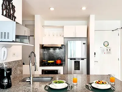 a white kitchen with two plates of food on a counter at Morros Ultra 1 BR - Direct Sea View in Cartagena de Indias