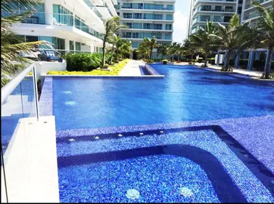 a swimming pool with blue water in front of a building at Morros Ultra 1 BR - Direct Sea View in Cartagena de Indias
