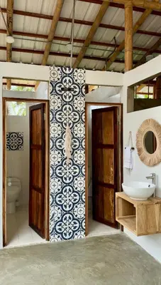 a bathroom with a sink and a toilet and a wall at Rincón del Mangle in San Onofre