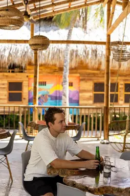 a man sitting at a table with a bottle of beer at Rincón del Mangle in San Onofre