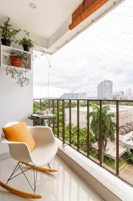 a room with a white chair and a balcony with a view at Bocagrande Excelente Ubicacion Apto CONFORT con una gran vista al MAR y PLAYAS in Cartagena de Indias