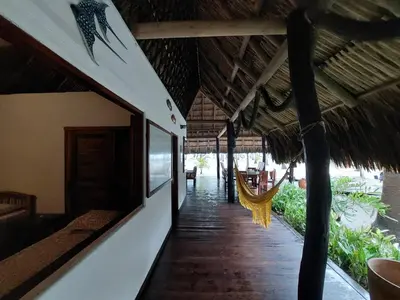 a hallway of a resort with a hammock on the floor at Cabaña frente al mar en la playa del Calao in San Antero