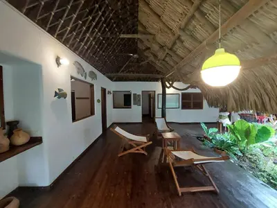 a living room with chairs and a ceiling at Cabaña frente al mar en la playa del Calao in San Antero