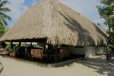 a hut with chairs and a straw roof at Cabaña frente al mar en la playa del Calao in San Antero