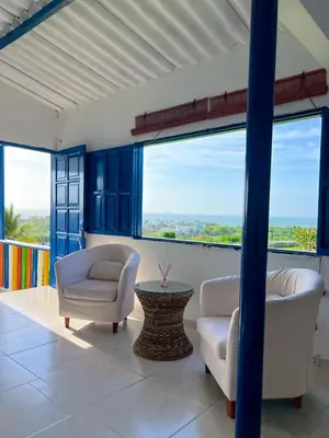 a living room with two chairs and a table and large windows at Liz&Mar Glamping in Tubará