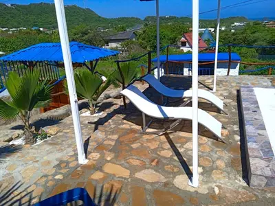 a patio with two chairs and an umbrella at Liz&Mar Glamping in Tubará