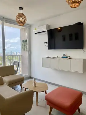 a living room with a couch and a tv on the wall at U-GO Sunset Frente al Mar in Cartagena de Indias