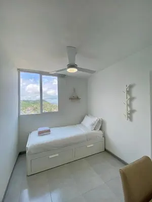 a white bedroom with a bed and a window at U-GO Sunset Frente al Mar in Cartagena de Indias