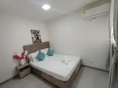 a bedroom with a large bed with blue pillows at U-GO Sunset Frente al Mar in Cartagena de Indias