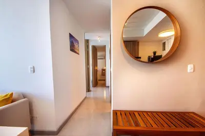 a room with a mirror and a wooden bench at U-GO Sunset Frente al Mar in Cartagena de Indias