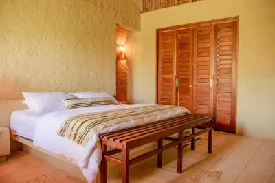 a bedroom with a bed and a wooden door at Exclusive 4BR Beach House in Tierra Bomba in Tierra Bomba