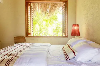 a bedroom with a large bed with a window at Exclusive 4BR Beach House in Tierra Bomba in Tierra Bomba