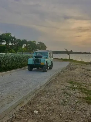 a blue jeep driving down a road near the water at Exclusive 4BR Beach House in Tierra Bomba in Tierra Bomba