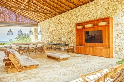 a large living room with a large stone wall at Exclusive 4BR Beach House in Tierra Bomba in Tierra Bomba