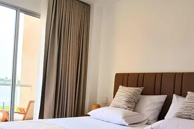 a bedroom with a bed with white pillows and a window at Vista impresionante y cama king en Baia Kristal in Los Arrayanes