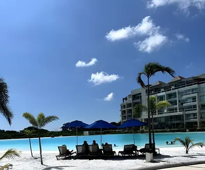 people sitting on chairs on the beach at the resort at Vista impresionante y cama king en Baia Kristal in Los Arrayanes