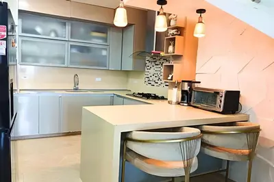 a kitchen with blue cabinets and a counter with stools at Dúplex Frente al Mar cerca C.Amurallada in Cartagena de Indias