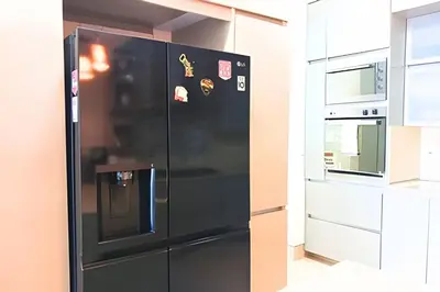 a black refrigerator in the middle of a kitchen at Dúplex Frente al Mar cerca C.Amurallada in Cartagena de Indias