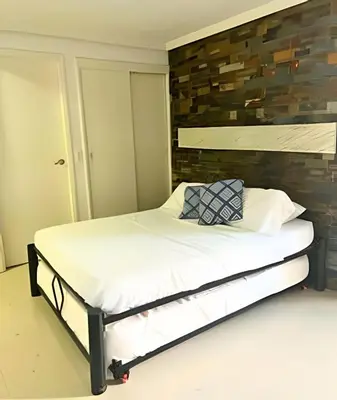 a bed in a room with a brick wall at Lindo Apartstudio en El Laguito in Cartagena de Indias